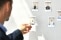 The picture shows a man in front of a wall with portraits
