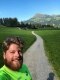 The image shows a man in front of a natural path.