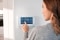 The image shows a women touching the Busch-free@home® smart home system 