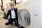 Das Bild zeigt Phil Pallister, Geschäftsführer von PHS, neben einer Wärmepumpe