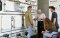 The image shows a group of people in front of radiators.