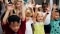 Image shows laughing children with arms up.