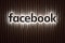 The image shows the illuminated Facebook logo.