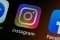 The image shows the Instagram logo on a smartphone screen.